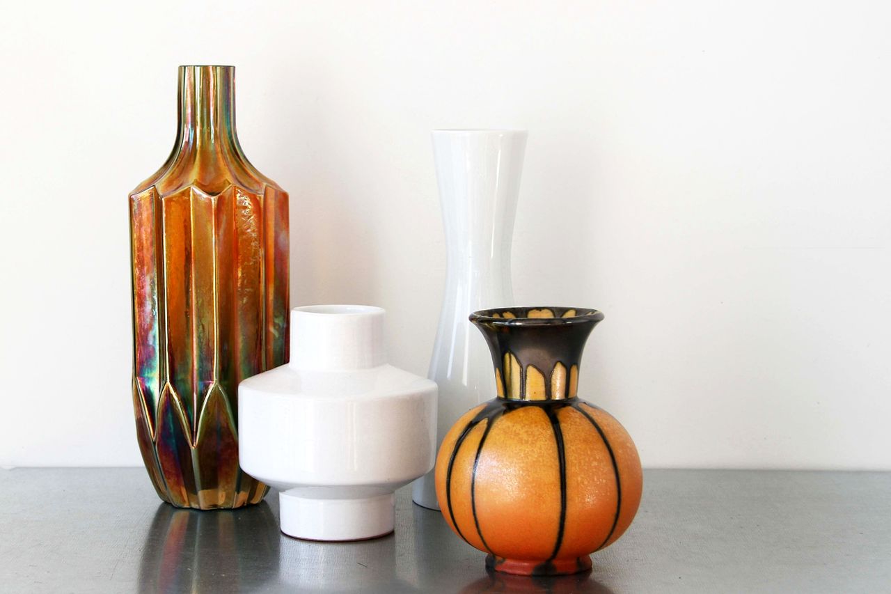 A stylish arrangement of colorful ceramic vases on a reflective surface, perfect for home decor inspiration.