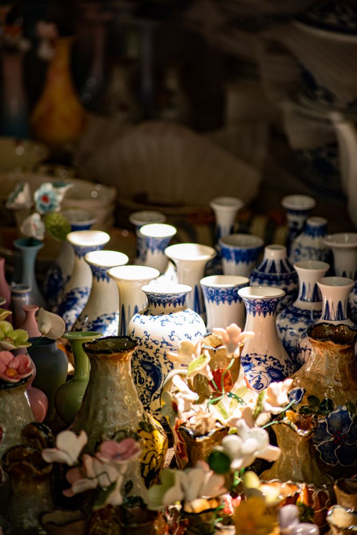 About A collection of intricately designed ceramic vases with floral patterns, beautifully lit.